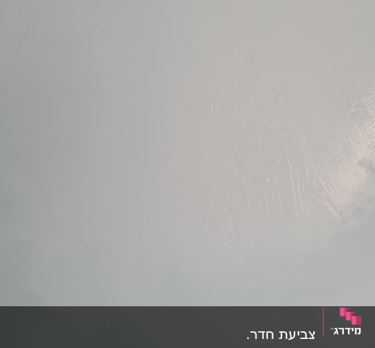 קיר צבוע בגוון אפור עם סימני מברשת